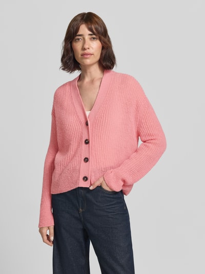 Frauenmodel trägt Strickjacke aus Alpaka-Mix mit V-Ausschnitt von Closed in Rosa mit Knopfleiste, relaxed Fit, Ganzkörperansicht von vorne.