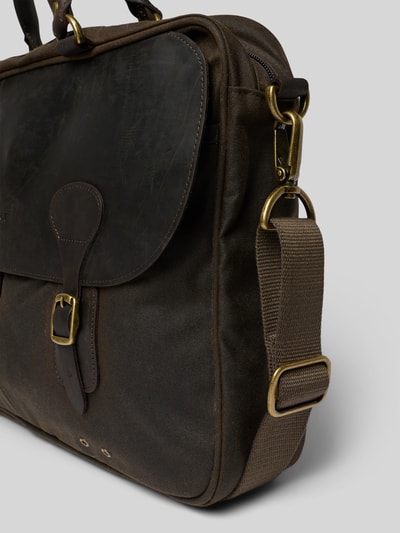 Produktfoto, Laptoptasche aus gewachster Baumwolle von Barbour in Braun mit Lederverschluss, Reißverschluss und Schulterriemen, unifarbene Optik, Vorder- und Netzfach, Materialmix Baumwolle und Leder, Detailaufnahme von schräg vorne.