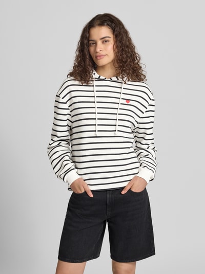 Frauenmodel trägt Regular Fit Hoodie aus Baumwoll-Mix Modell 'CHILLI' von PIECES, weiße Grundfarbe mit schwarzen Streifen, Ganzkörperansicht von vorne.