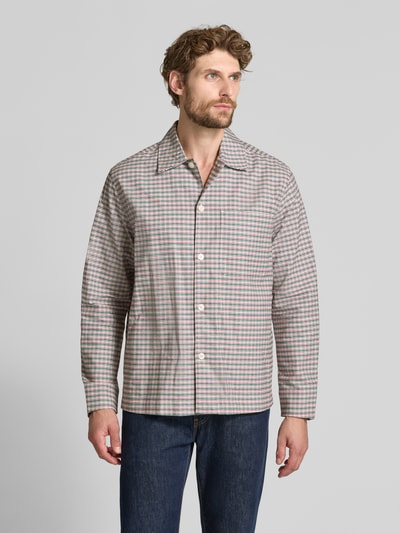 Männermodel trägt Freizeithemd mit Umlegekragen aus reiner Baumwolle von Selected, kariertes Allover-Muster, langarm, Knopfleiste, Ganzkörperansicht von vorne.