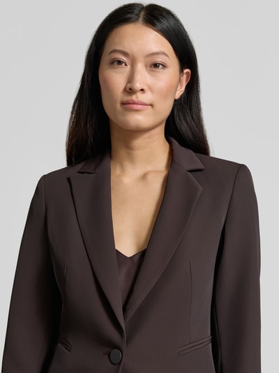 Vrouwenmodel draagt Slim Fit Blazer met reverskraag van Rinascimento in donkerbruin met knoopsluiting en paspelzakken, Nahaufnahme bovenlichaam.