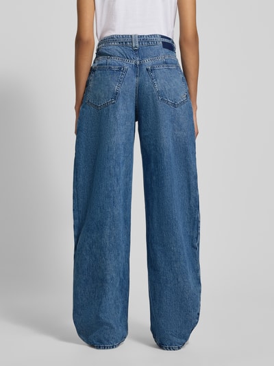 Frauenmodel trägt Wide Leg Jeans aus Baumwoll-Lyocell-Mix Modell 'C_PLEATED BARREL 1.0' von BOSS Orange in Denim-Optik mit Label Patch, Nieten, Bundfalte, Bindegürtel, seitlichen Eingrifftaschen und Gesäßtaschen, Ganzkörperansicht Rückansicht.