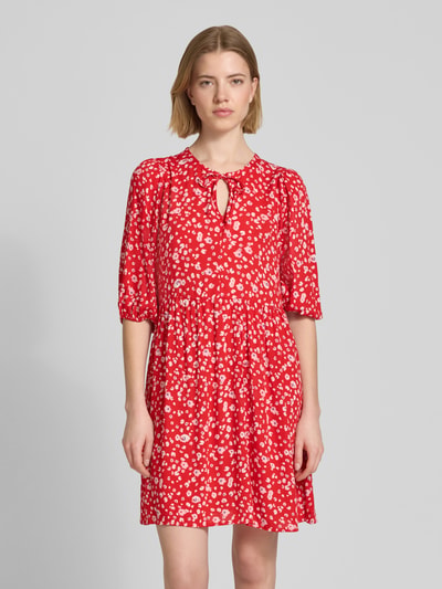 Frauenmodel trägt Minikleid aus Reine Viskose im Allover-Look Modell 'MARRAKECH' von ICHI, rote A-Linie mit weißen Motiven, Ganzkörperansicht von vorne. Rückenlänge bei Größe S: 34 cm, Brustweite bei Größe S: 35 cm, Ärmellänge bei Größe S: 37 cm.