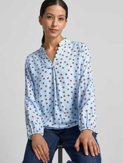 Frauenmodel trägt Relaxed Fit Bluse aus reiner Viskose-Mix Modell 'Valeria' von ZABAIONE, Serafino Ausschnitt, blau mit braunen Punkten, Langarm, Ganzkörperansicht von vorne.