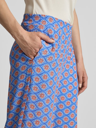 Frauenmodel trägt Wide Fit Stoffhose aus reiner Viskose mit Allover Motiv-Print von Smith and Soul, hellblau mit Muster, Nahaufnahme Oberkörper, elastischer Bund, Allover-Motiv, Damen Stoffhose.