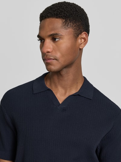 Männermodel trägt Slim Fit Strick-Poloshirt mit V-Ausschnitt von Lerros in Dunkelblau, Strukturmuster, Reine Baumwolle, Nahaufnahme Oberkörper.