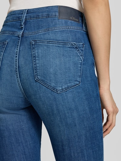 Kobieta nosi Skinny Fit Jeans aus Baumwoll-Mix Modell 'Izabell' od s.Oliver RED LABEL, średnio-niebieski denim, zbliżenie tylnej części, widok z tyłu