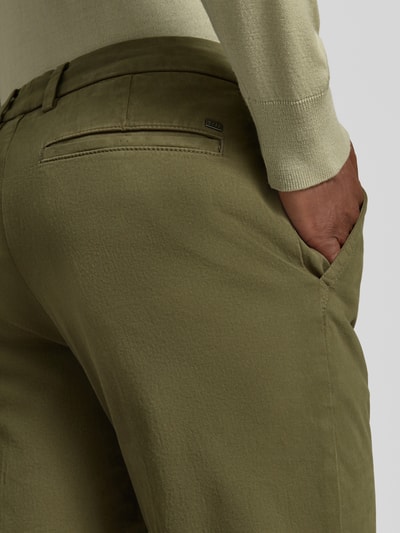 Mężczyzna nosi Slim Fit Chino aus Baumwoll-Mix model 'Kaiton1' od BOSS, zielony kolor, wyraźna tekstura tkaniny, detal tylnej kieszeni, Herren spodnie BOSS, detal tylnego widoku.