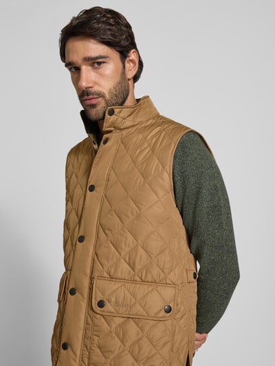 Männermodel trägt gesteppte, beige Slim Fit Weste mit Logo-Stitching Modell 'NEW LOWERDALE' von Barbour, Herren Weste, Nahaufnahme Oberkörper.