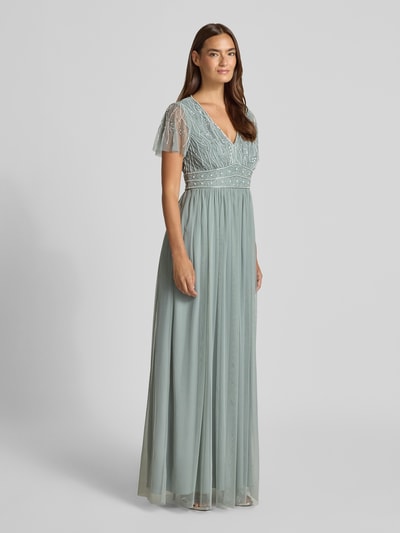 Frauenmodel trägt Abendkleid mit Paillettenbesatz von Christian Berg Cocktail aus Chiffon, A-Linie, Maxikleid, V-Ausschnitt, Schmetterlingsärmel, sanft grüne Farbe, feine Textur, Rückseitiger Haken- und Reißverschluss, Rückenlänge bei Größe 36: 159 cm, Brustweite: 41 cm, Ärmellänge: 19 cm, Ganzkörperansicht von vorne.