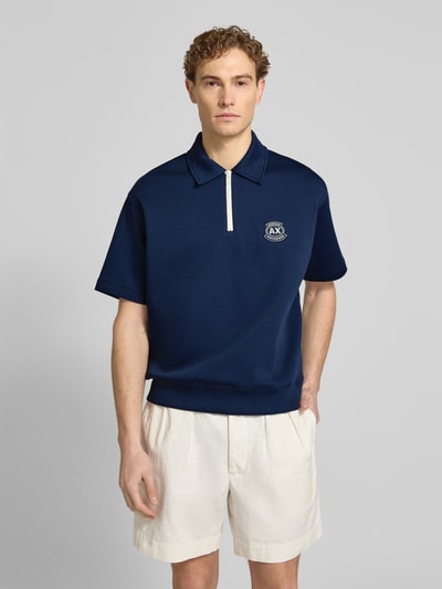 Männermodel trägt Loose Fit Poloshirt mit Label-Stitching von ARMANI EXCHANGE, dunkelblau, Baumwoll-Mix, Nahaufnahme Oberkörper.