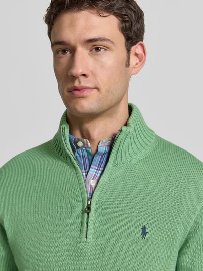 Männermodel trägt Troyer mit Label-Stitching von Polo Ralph Lauren aus reiner Baumwolle, Regular-Fit, gerippte Abschlüsse, Stehkragen, kurzer Reißverschluss, Nahaufnahme Oberkörper.