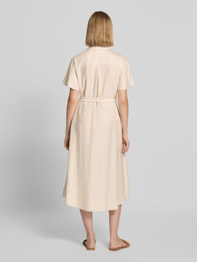 Frauenmodel trägt Midikleid aus Viskose-Mix mit Umlegekragen von COMMA in Beige, lockere Textur, leicht tailliert, Ganzkörperansicht Rückansicht.