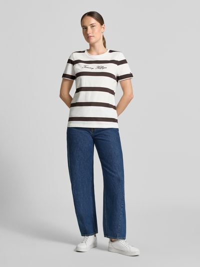 Vrouwenmodel draagt Regular Fit t-shirt uit puur katoen van Tommy Hilfiger met brede bruine en witte strepen, dames t-shirt, volledige vooraanzicht.