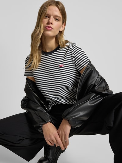 Frauenmodel trägt T-Shirt mit Label-Stitching Modell 'THE PERFECT TEE' von Levi's®, schwarz-weiß gestreift, reine Baumwolle, Nahaufnahme Oberkörper.