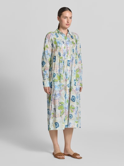 Frauenmodel trägt Relaxed Fit Midikleid aus reiner Baumwolle von Christian Berg Woman mit floralem Allover-Print, langärmelig, Knopfleiste, Falten, zarte Pastellfarben und weiche Textur, Ganzkörperansicht von vorne.