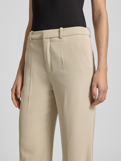 Frauenmodel trägt Hose mit Bügelfalten Modell 'ARGUE' von Drykorn in Beige, Material-Mix mit Stretch, Nahaufnahme Oberkörper.
