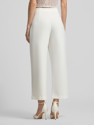 Frauenmodel trägt Straight Fit Stoffhose mit Viskose-Anteil Modell 'Leonie' von GUIDO MARIA KRETSCHMER WOMAN in Weiß, weites Bein, Ziernähte, Ganzkörperansicht Rückansicht.