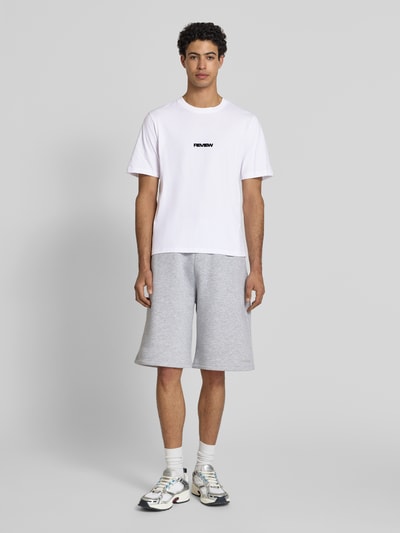 Męski model nosi T-Shirt mit Logo und Rundhalsausschnitt od REVIEW z bawełny, krój relaxed fit, długość tyłu 68 cm, Ganzkörperansicht von vorne