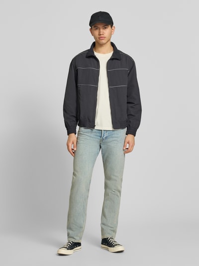 Männermodel trägt Relaxed Fit Jeans im Used-Look Modell 'CHRIS' von Jack & Jones in hellem Blau, reine Baumwolle, Ganzkörperansicht von vorne.