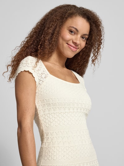 Frauenmodel trägt Strickkleid mit Strukturmuster und Wellensaum von REVIEW, Reine Baumwolle, Gerader-Schnitt, Nahaufnahme Oberkörper.