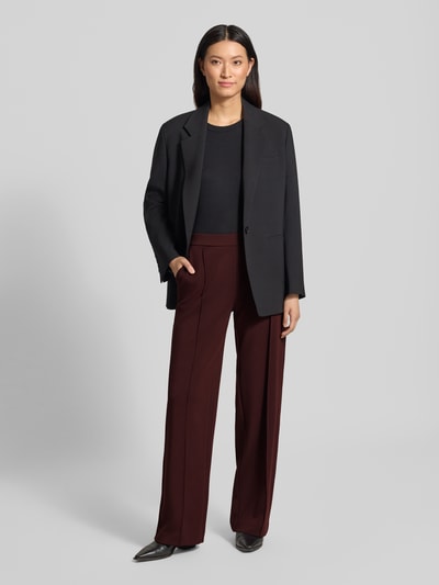 Frauenmodel trägt Relaxed Fit Weite Hose aus Modal-Mix Modell 'Melane Chill' von OPUS in Dunkelrot mit schwarzem Oberteil, Damen Weite Hose von OPUS, Ganzkörperansicht von vorne.