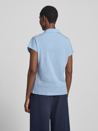 Frauenmodel trägt Regular Fit Poloshirt aus reiner Baumwolle von s.Oliver RED LABEL in Hellblau, glatte Textur, Ganzkörperansicht Rückansicht.