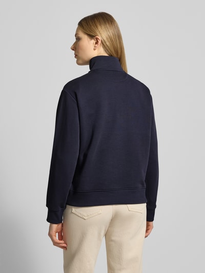 Frauenmodel trägt Sweatshirt mit Baumwoll-Anteil von Gant in Dunkelblau, lockerer Schnitt, Troyer-Kragen, Rückenansicht, Ganzkörperansicht Rückansicht.
