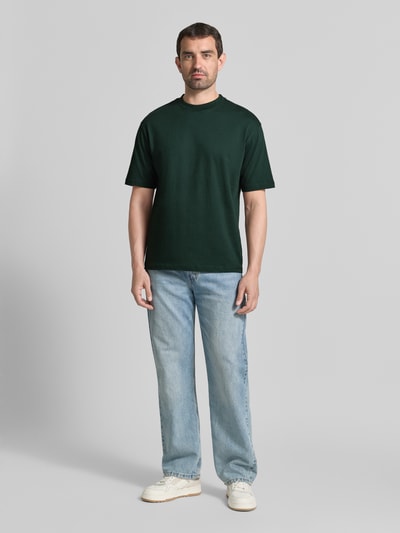 Männermodel trägt Regular Fit T-Shirt mit Rundhalsausschnitt von MCNEAL in Dunkelgrün, reine Baumwolle, kurzärmelig, Ganzkörperansicht von vorne