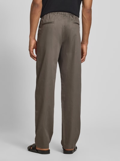 Männermodel trägt Hose mit elastischem Bund und Gesäßtaschen von Emporio Armani in Braun, Material-Mix, Ganzkörperansicht Rückansicht.
