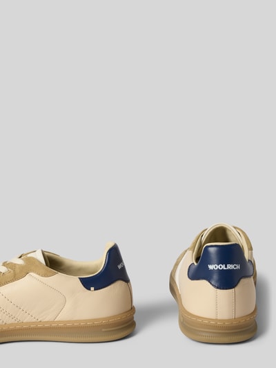 Produktfoto, Sneaker aus Leder mit Gummisohle von Woolrich in Beige und Blau, abgerundete Spitze, Schnürung, 3 cm Absatzhöhe, 6 cm Schafthöhe, 7 cm Schaftweite, Echtleder, Rückansicht und Seitenansicht, glatte Textur.