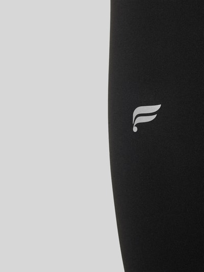 Produktfoto, schwarze Slim Fit Leggings mit Logo-Print von Fabletics aus elastischem Material-Mix, glatte Textur, knöchellang