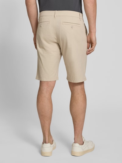 Mężczyzna nosi Regular Fit Bermudas aus Baumwoll-Mix Modell 'PHOENIX' od s.Oliver RED LABEL, jasnobeżowy twill, tył, 5 kieszeni, długość cropped, krój regular fit, widok całej sylwetki z tyłu.