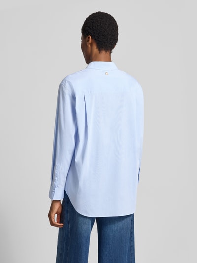 Frauenmodel trägt Loose Fit Hemdbluse aus Viskose-Mix Modell 'Beora' von JOOP! in Hellblau mit feiner Struktur, Ganzkörperansicht Rückansicht. Damen Hemdbluse von JOOP!