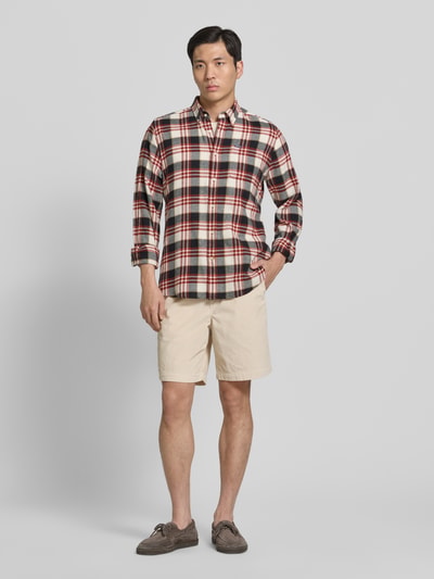 Męski model nosi Regular Fit Sweatshorts aus Baumwoll-Mix od SELECTED HOMME, kremowy, sztruks, krój regular fit, widok całej sylwetki z przodu.
