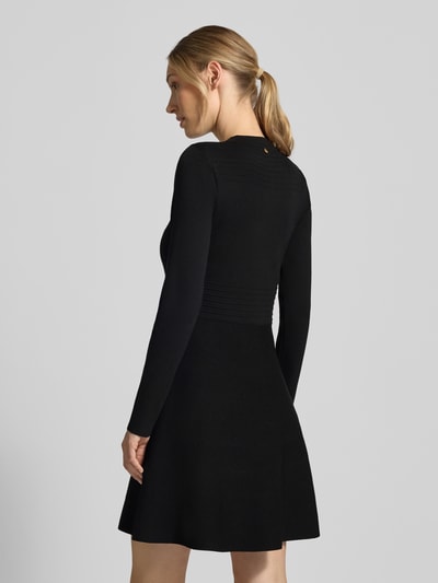 Frauenmodel trägt Slim Fit Minikleid aus Viskose-Mix Modell 'Abito Maglia' von Liu Jo White, Schwarz, Zierbesatz, Rückansicht, Ganzkörperansicht.