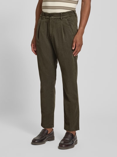 Mężczyznę model nosi spodnie Regular Fit Hose mit Eingrifftaschen Modell 'CHASY' od DRYKORN, mieszanka lyocellu i bawełny, oliwkowy, wpuszczane kieszenie, szerokość w rozmiarze 32/32: 41 cm, długość wewnętrzna nogawki: 71 cm, widok całej sylwetki z przodu.