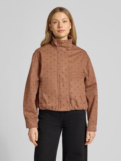 Frauenmodel trägt Jacke mit verdecktem Reißverschluss Modell 'DOTS' von Mango in Braun mit schwarzen Punkten, reine Baumwolle, Stehkragen, Eingrifftaschen, Regular Fit, Ganzkörperansicht von vorne.