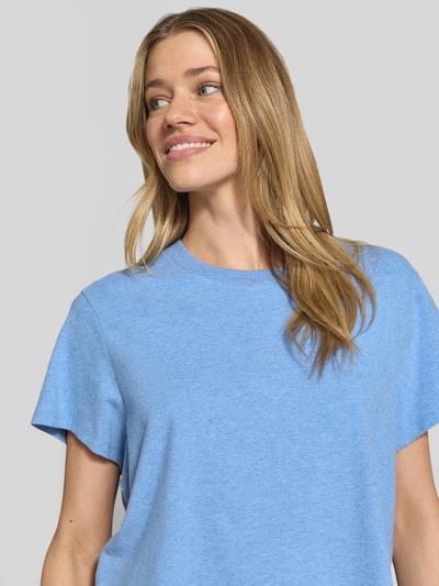 Frauenmodel trägt T-Shirt mit geripptem Rundhalsausschnitt von American Vintage in Hellblau, lockerer Schnitt, Nahaufnahme Oberkörper. Baumwoll-Modal-Mix mit Stretch.