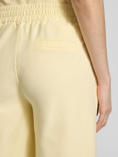Frauenmodel trägt Hose in verkürzter Passform Modell 'KATE' von ICHI aus gelbem Baumwoll-Mix mit Stretch-Anteil, Detailaufnahme Rücken.