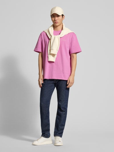 Mannenmodel draagt T-Shirt met Logo-Print Modell 'Crew' van Les Deux, rechte fit, ronde hals, zuivere katoen, roze kleur, volledige lichaamsvoorzijde