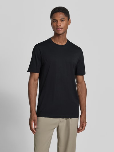 Męski model nosi Regular Fit T-Shirt mit Logo-Stitching od MCNEAL z bawełny, okrągły dekolt, czarny, długość tyłu 70 cm w rozmiarze M, Ganzkörperansicht von vorne