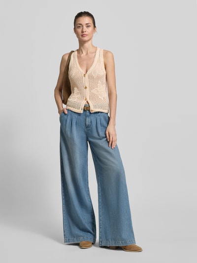 Kobiece model nosi kamizelkę dzianinową z dekoltem w serek model 'LASTICE' od Marella, czysta bawełna, krój slim fit, listwa guzikowa, długość tyłu w rozmiarze S: 56 cm, jasne kolory, wyraźna faktura dzianiny, pełny widok z przodu.