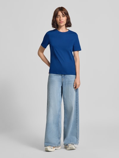 Vrouwenmodel draagt Regular Fit t-shirt van puur katoen model 'PAULINA' van VERO MODA in effen blauw met lichte jeans, volledig vooraanzicht