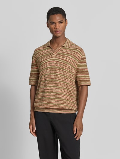 Männermodel trägt Relaxed Fit Poloshirt aus reiner Baumwolle Modell 'Muse' von SELECTED HOMME, gestreift, Strick, Ganzkörperansicht von vorne.