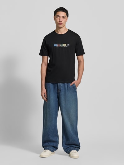 Männermodel trägt schwarzes T-Shirt aus Bio-Baumwolle Modell 'NANTUCKET' von Jack & Jones in geradem Schnitt, Ganzkörperansicht von vorne