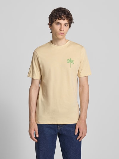 Männermodel trägt T-Shirt mit Motiv-Print Modell 'SUN PALMS' von Blend in Beige, Rundhalsausschnitt, reine Baumwolle, Ganzkörperansicht von vorne.