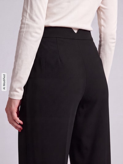 Frauenmodel trägt Wide Leg Weite Hose mit Viskose-Anteil Modell 'STELLA' von VERO MODA in Schwarz, Nahaufnahme Rückansicht, Damen Weite Hose, KI-modifiziertes Bild.