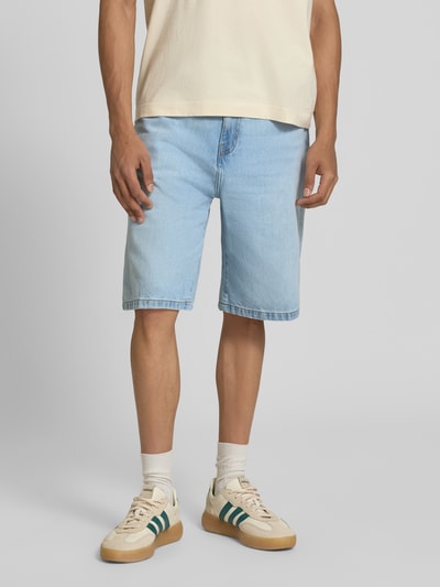 Männermodel trägt Jeansshorts mit Eingrifftaschen Modell 'Robertson' von Carhartt Work In Progress in Hellblau, Reine Baumwolle, Relaxed-Fit, Ganzkörperansicht von vorne.