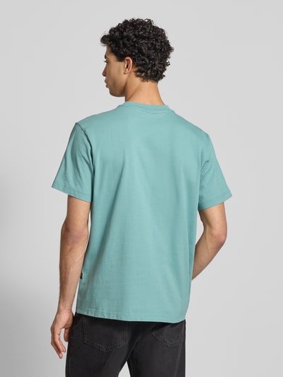 Männermodel trägt Regular Fit T-Shirt mit Logo-Print Modell 'icon' von G-Star Raw in Hellblau aus reiner Baumwolle, Ganzkörperansicht Rückansicht.